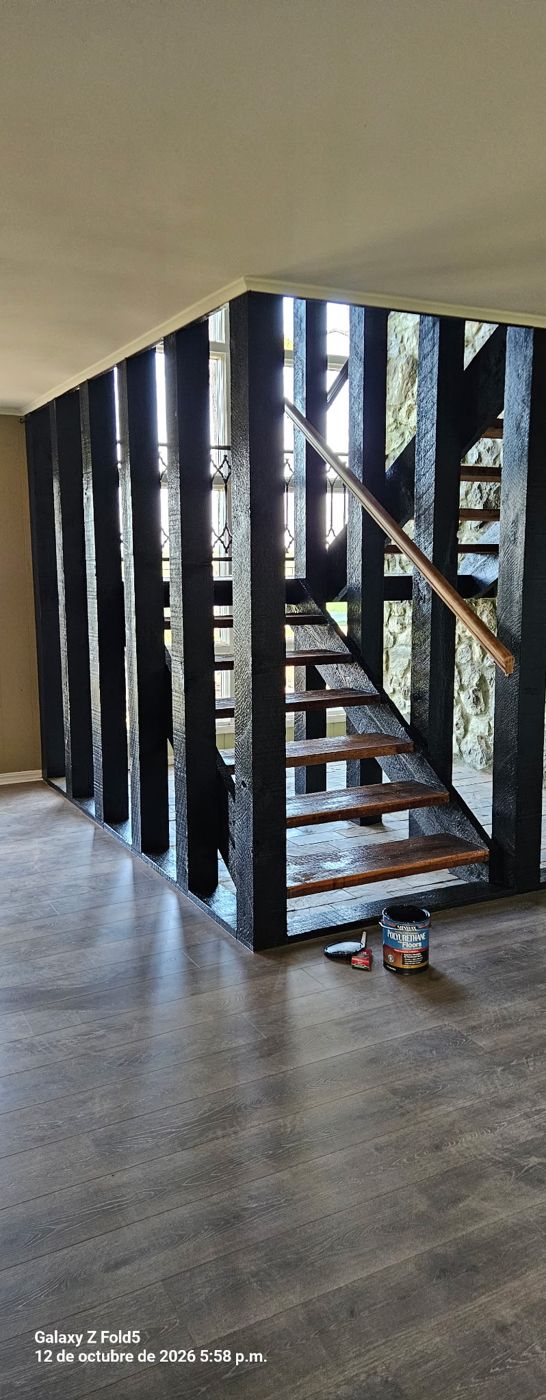 Staircase with black painted railing and wood treads